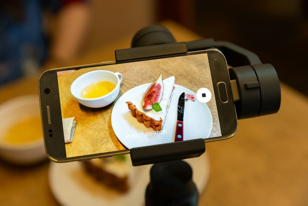 A person taking a picture of food on a cell phone